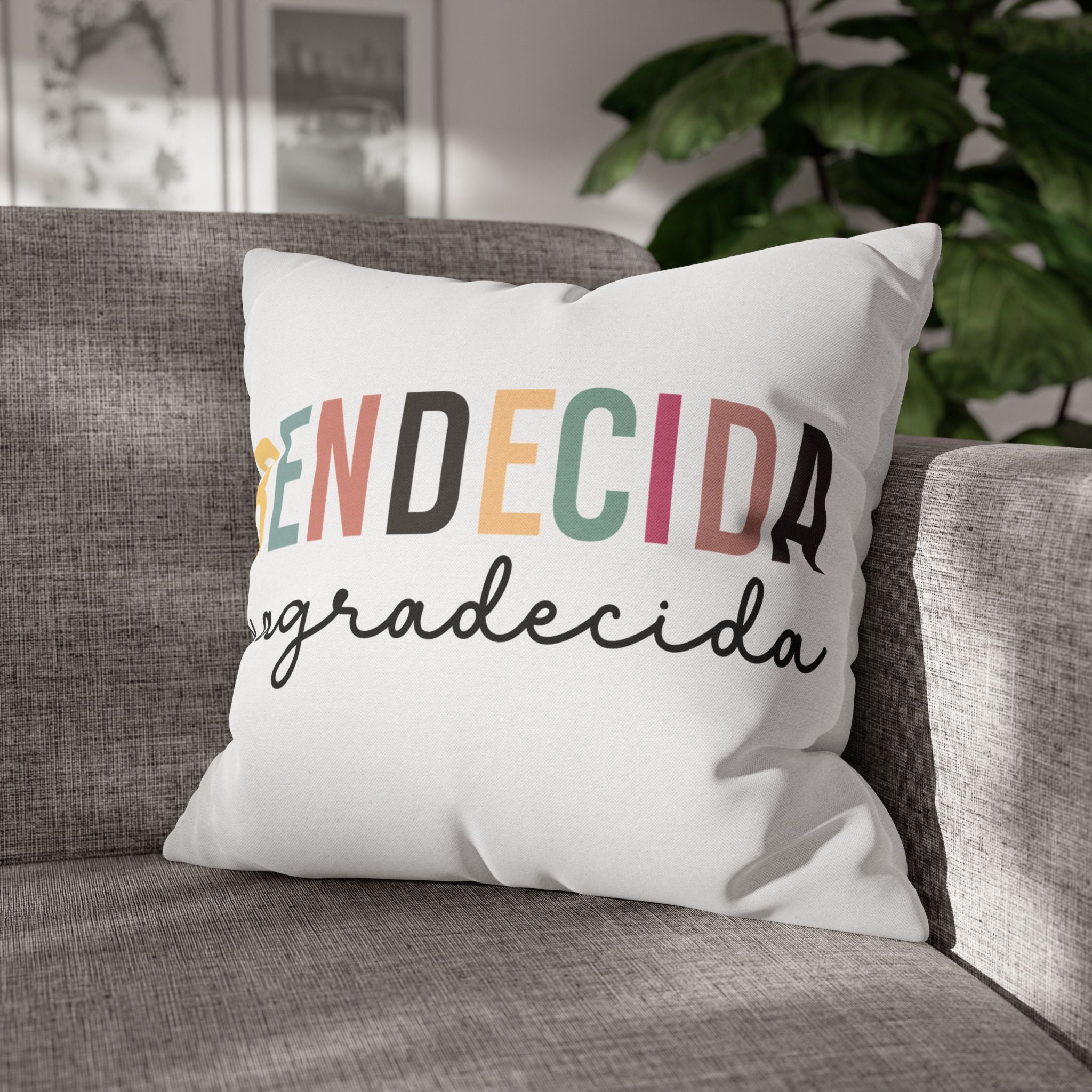 Personalized indoor pillow cover with colorful text 'en decidida agradecida' on a cozy sofa.